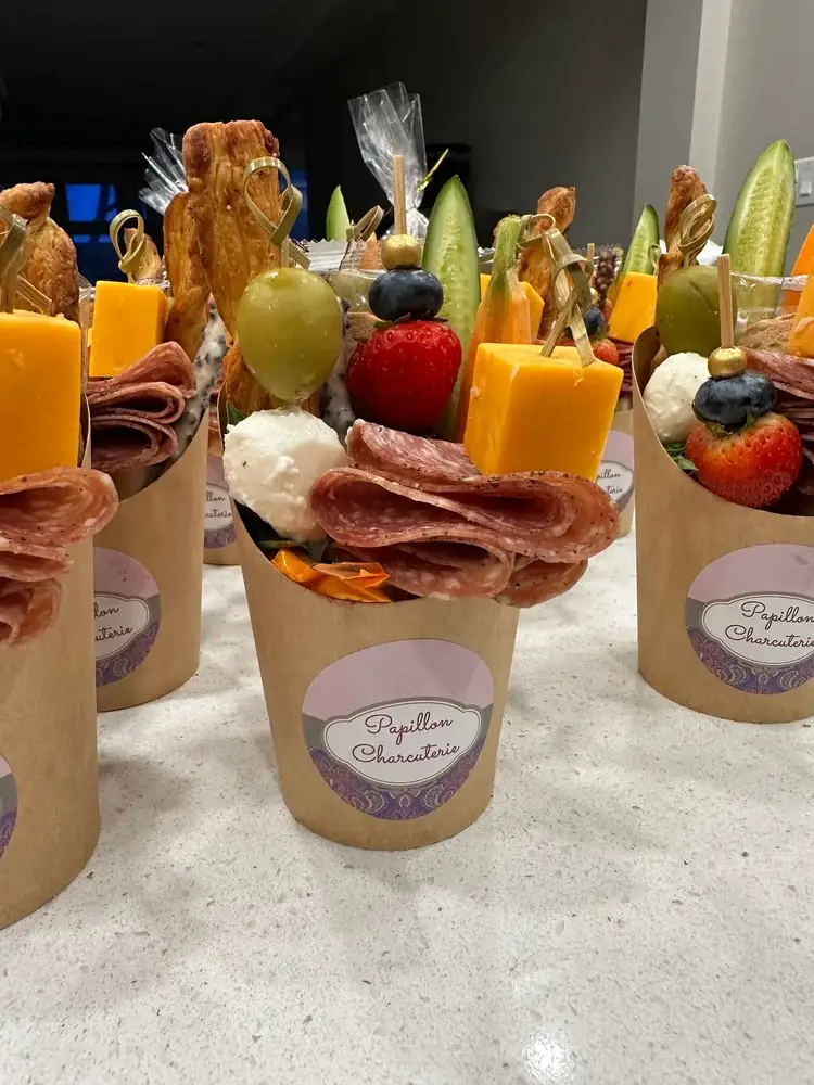 First image of individual charcuterie cup with cured meats, cheese cubes, and fruit Papillon Charcuterie single-serving cup with gourmet snacks for Hamilton events – image 1 Compact charcuterie cup with assorted finger foods, perfect for weddings and gatherings